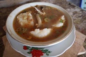 Coto Makassar food from Indonesia with some meat and lontong photo