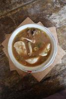Coto Makassar food from Indonesia with some meat and lontong photo