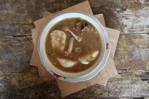 Coto Makassar food from Indonesia with some meat and lontong photo