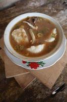 Coto Makassar food from Indonesia with some meat and lontong photo