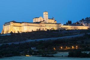 Basílica de Asís por la noche, región de Umbría, Italia. la ciudad es famosa por la basílica italiana más importante dedicada a st. francis - san francesco. foto