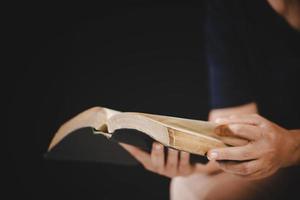 mujer joven persona mano sosteniendo la sagrada biblia con estudio en casa. libro de lectura cristiana femenina adulta en la iglesia. niña aprendiendo religión espiritualidad con oración a dios. concepto de fe en la educación de los estudiantes. foto