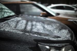 Car in parking lot. Raindrops on car. Transport in detail. photo