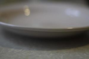 Plate on table. Empty plate in kitchen. Dishes for eating. photo