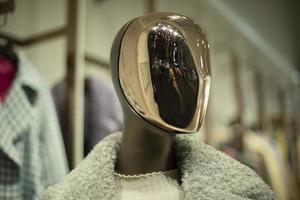 Golden mask on face of mannequin. Details of style and fashion. Mannequin in clothing store. photo