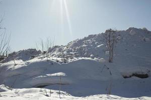 Mountain of snow in sunlight. Rays in snow. photo