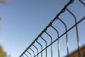 Fence made of steel bars. Fence made of netting in parking lot. Steel mesh. photo