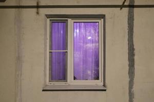 Window in building. Purple light in white window. Details of building. photo
