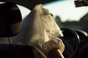 Bride is driving car. Woman in white veil in transport. photo