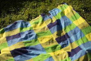 Green plaid on beach. Bedspread at picnic. Tablecloth for eating. Blanket for relaxation. photo