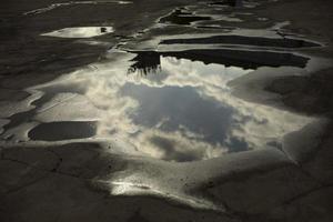 Large puddle on asphalt. Puddle after rain. Precipitation in city. photo