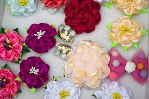 Flowers made of hair fabric. Hair clips of different colors. Fabric products for decoration. photo