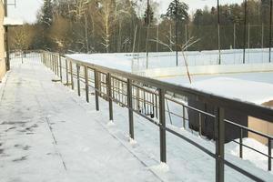 Details of ice rink in winter. Stand with barrier. photo