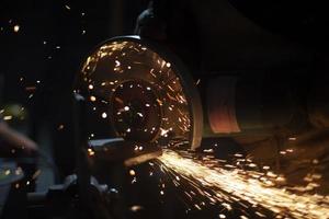 Sawing steel. Work of saw on metal. Cutting of steel profile. Sparks in dark. Master creates design. photo