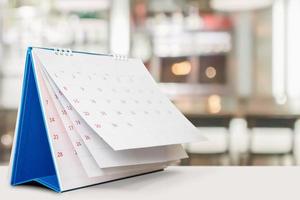 desk calendar on table with blurred bokeh background appointment and business meeting concept photo