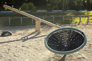 Children's playground with round swings. Details of park. Children's area in yard. photo