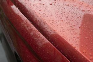 Raindrops on car. Red car is in details. photo