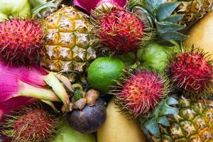 Fresh and ripe colorful fruits closeup. Dragon fruit, pineapple, lime, mango, rambutan, mangosteen, guava. photo