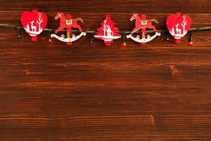 Red and white wooden Christmas decorations and Christmas lights on the brown wooden background, top view. photo