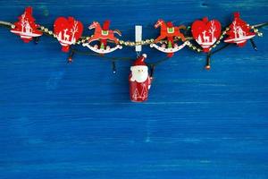 Christmas decorations and Christmas lights on the blue wooden background, top view. photo