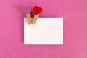 White sheet with red and purple pins on the pink background for Valentine Day. Copy space. photo