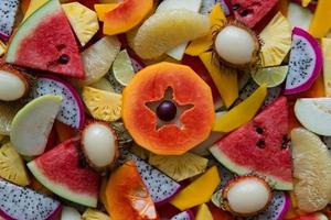 Mixed ripe and fresh fruits closeup for colorful background. Dragon fruit, pineapple, papaya, lime, mango, pomelo, rambutan, plum, watermelon. photo