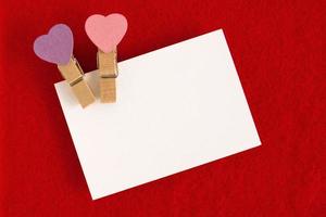 White sheet with pink and purple pins on the red background for Valentine Day. Copy space. photo