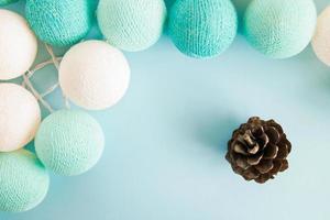 Cone on the blue background with blue and white lights made of yarn threads, top view. Christmas decorations. photo