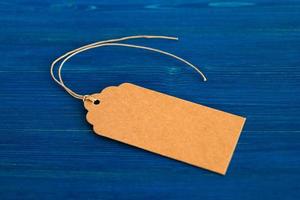 Brown blank paper price tag or label set on the blue wooden background, top view. photo
