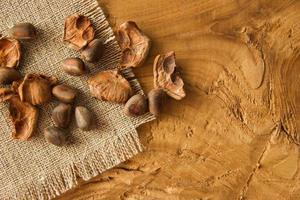 Pine nuts and a shuck closeup on a napkin from sackcloth on a wooden background. photo