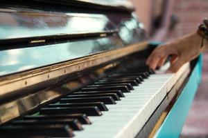 A hand of a young man playing piano on a street of city, closeup. photo