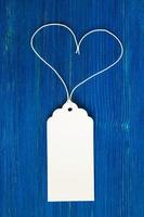 White blank paper price tag or label set on the blue wooden background, closeup. photo