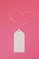 White blank paper price tag or label on the pink background, top view. photo