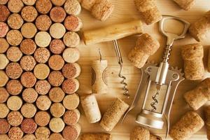 Wine corks and two corkscrews on the wooden background, top view. photo