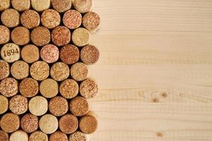 un montón de corcho de vino con textura de vino en el primer plano de fondo de madera, vista superior.