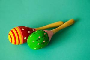 Green and red maracas on the blue background. photo