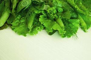 Green vegetable - salad, basil, dill, sorrel, peas, cucumber - on the white background, top view. photo