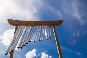 Wind musical chimes on the background of blue cloudy summer sky. photo