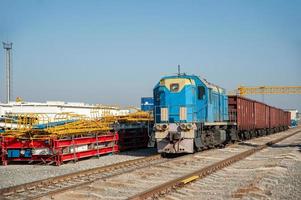 An old train on the railway tracks in the industrial construction on a sunny day photo