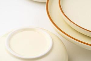 A set of white and brown ceramic plate and bowl on a white background photo