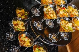 una mesa de buffet con vasos de ponche con frutas y jugo foto