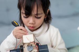 Inventive kid constructing robot cars at home photo