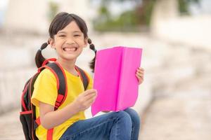 una joven asiática lee un libro, aprende el concepto de habilidades. foto