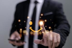 el consumidor respondió la encuesta de forma conceptual. el cliente crea un símbolo sonriente de cara feliz con un bolígrafo digital. la noción de felicidad del cliente y experiencia de servicio. foto