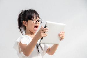 Shocked and surprised little girl on the internet with digital tablet computer concept for amazement, astonishment, making a mistake, stunned and speechless or seeing something he should not see photo