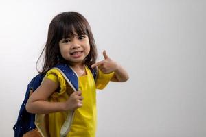 Asian young girl showing her arm with yellow bandage after got vaccinated or inoculation, child immunization, covid delta vaccine concept photo