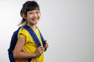 Asian young girl showing her arm with yellow bandage after got vaccinated or inoculation, child immunization, covid delta vaccine concept photo