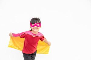 Funny little girl playing power superhero over white background. superhero concept. photo