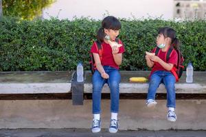 Kids eating outdoors at the school. Healthy school breakfast for children. Sandwich time. photo