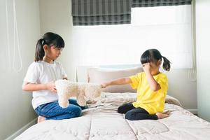 two little girl fighting over bear photo